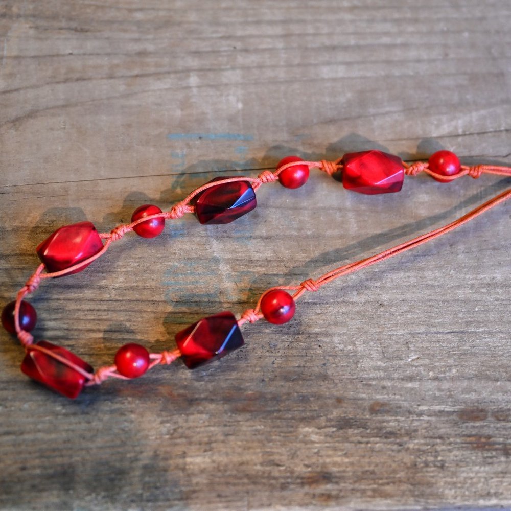 Collier à perles rouges sur ficelle de coton et fermoir métallique